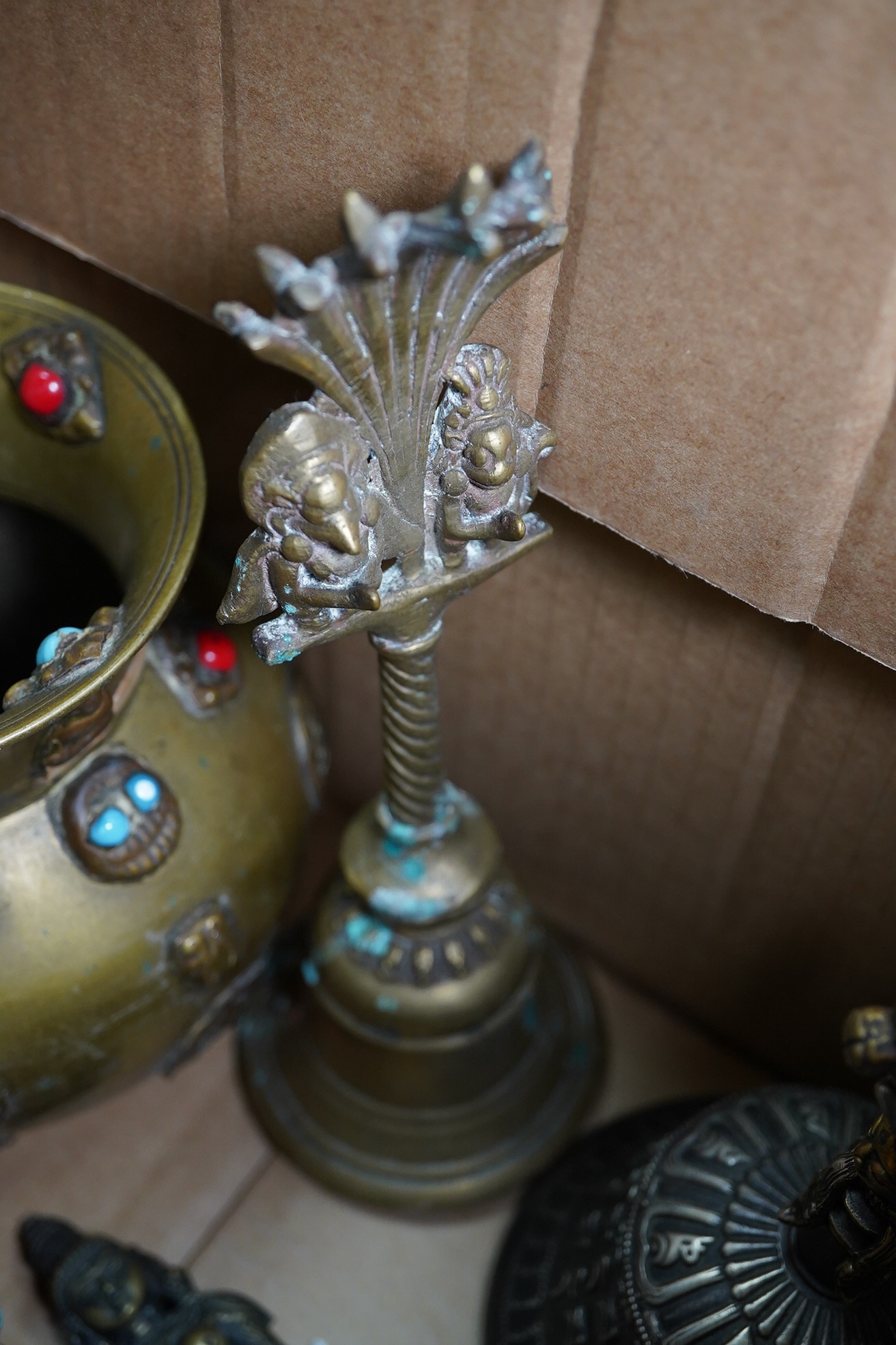 A group of Tibetan brass and mixed metal artefacts to include a brass vase with cabochon inset stones and figures of deities, largest 22cm high. Condition - mostly fair